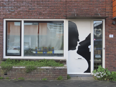 902237 Afbeelding van een schildering van twee mensen die op het punt staan elkaar te zoenen, op de voordeur van de ...